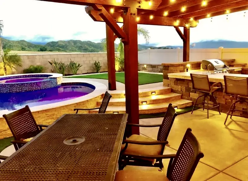 Built-in grill and bar-height counter beside the pool, under the pergola