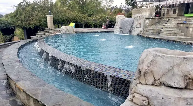 Water on: sheer descents spilling from the raised wall, with a rock waterfall