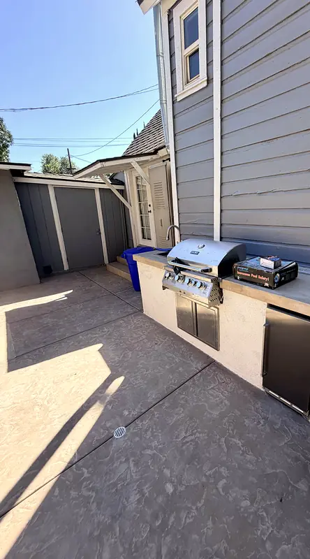 Built-in BBQ island with a stainless grill, griddle, and refrigerator