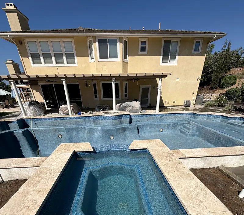 Raised spa with travertine coping and a new blue finish, just before filling